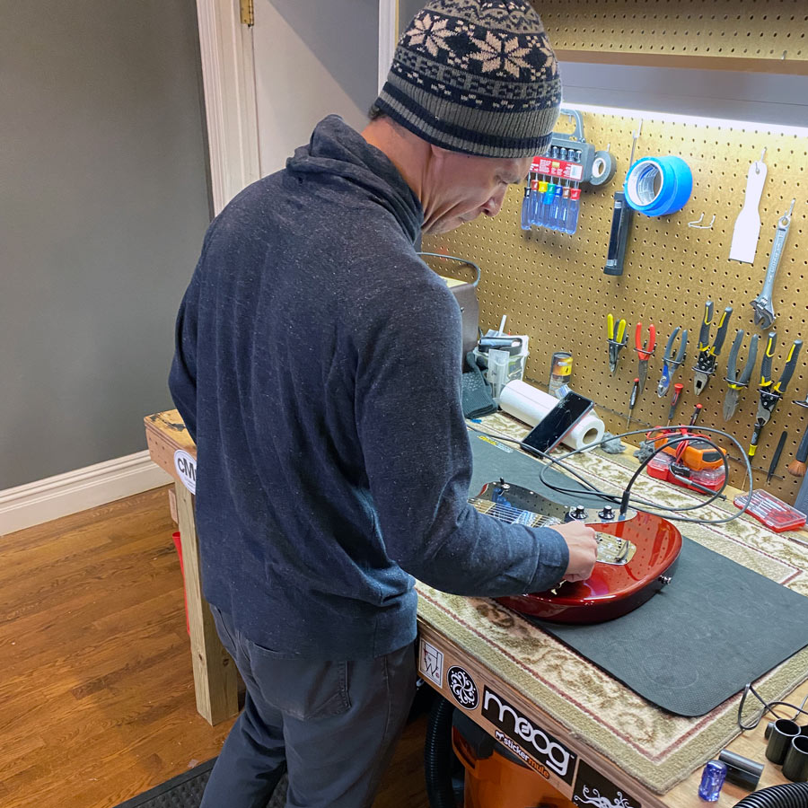 Man fixing guitar at Relic Music Shop